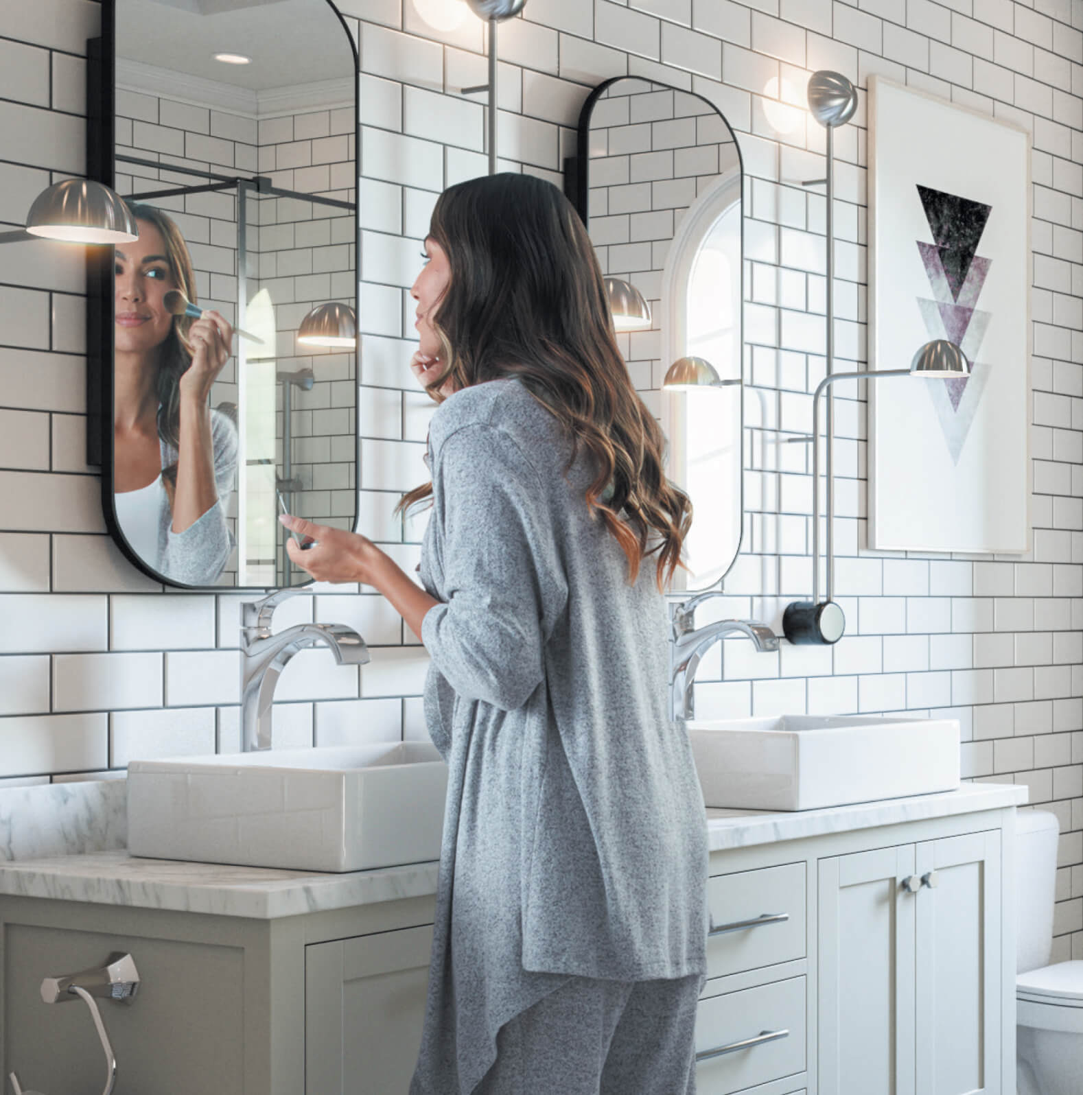 Woman putting makeup in bathroom mirror